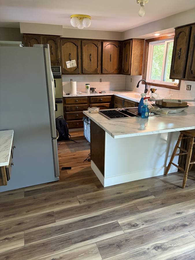 Kitchen with new marble-look countertops, tile backsplash and LVP flooring