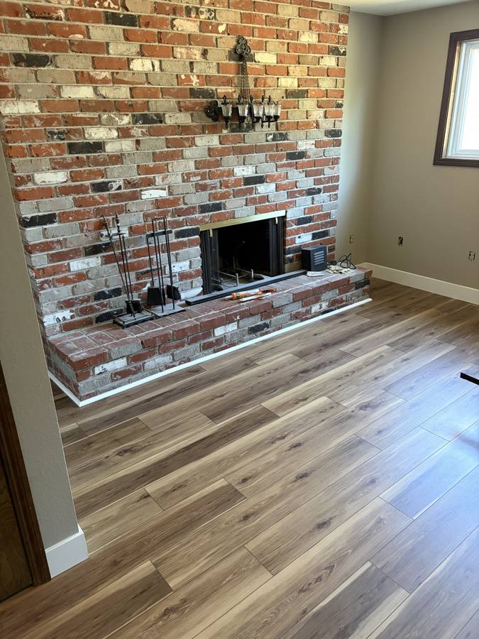 New LVP flooring and trim around a brick fireplace