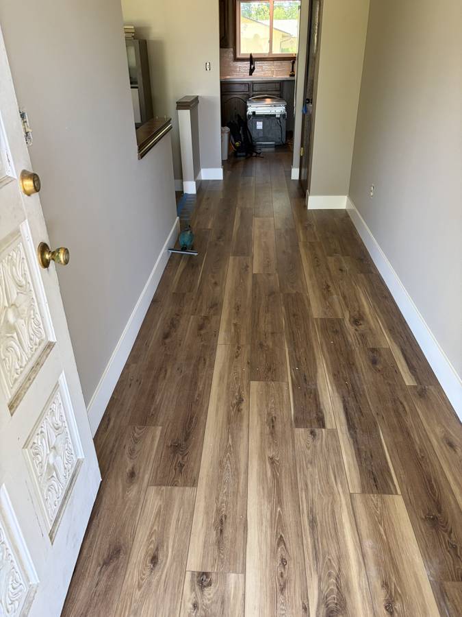 Entry hallway with new LVP flooring and white baseboards