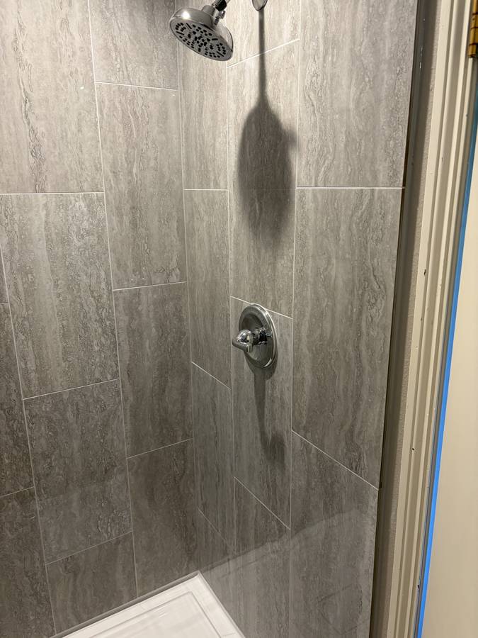 Tiled walk-in shower with new chrome fixtures