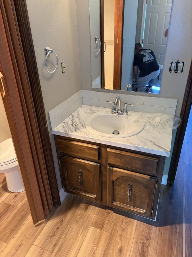 Half bath vanity with new countertop and tile backsplash