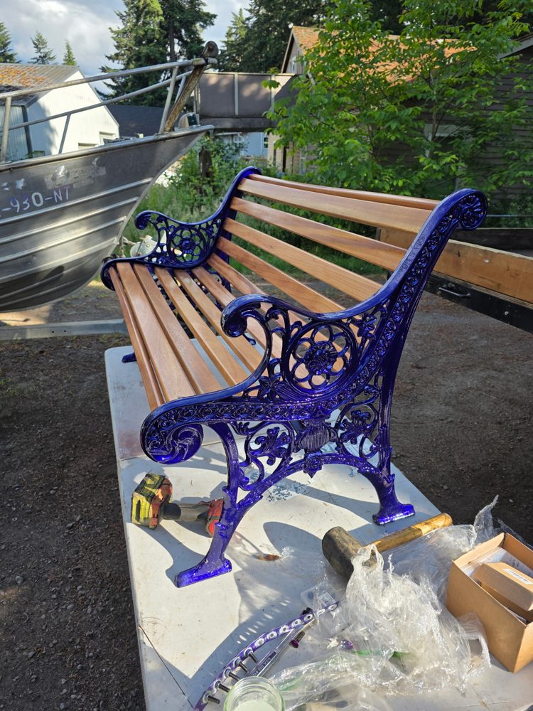 Restored cast iron bench, side view of the ornate blue scrollwork