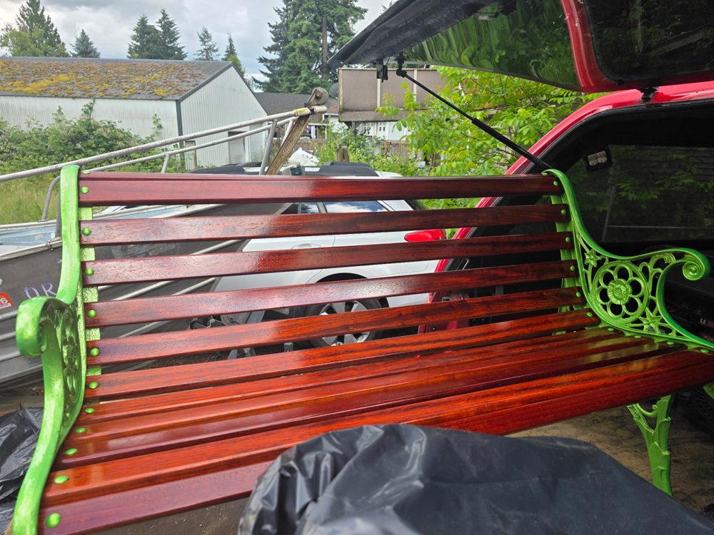 Restored bench with lime green cast iron and deep red stained, high-gloss slats