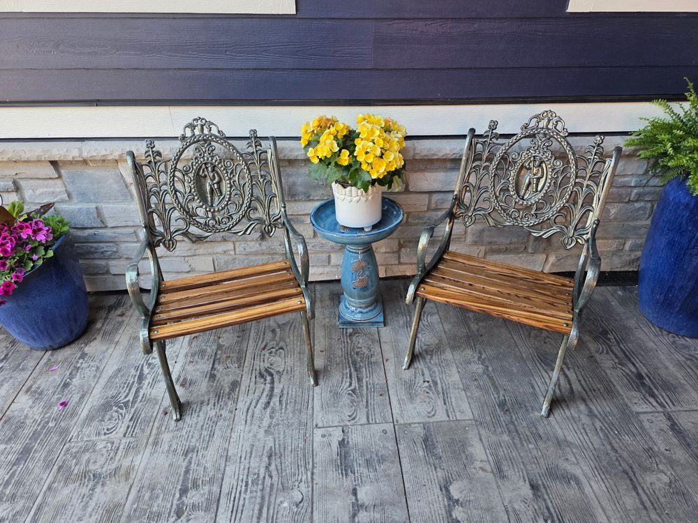 Pair of restored cast iron chairs with an antique bronze finish and new wood seats