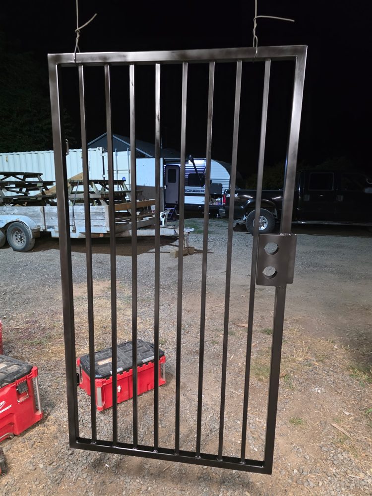 Steel picket walk gate in the shop after welding, with a lockset mounting plate