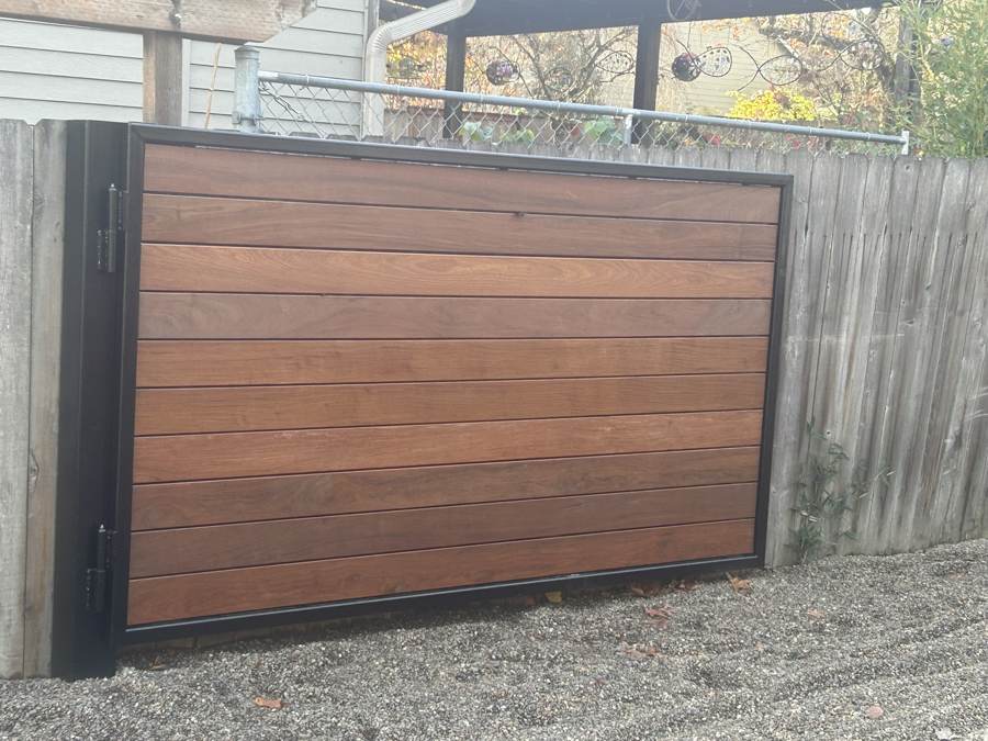 Single steel-framed hardwood gate set into a wood fence