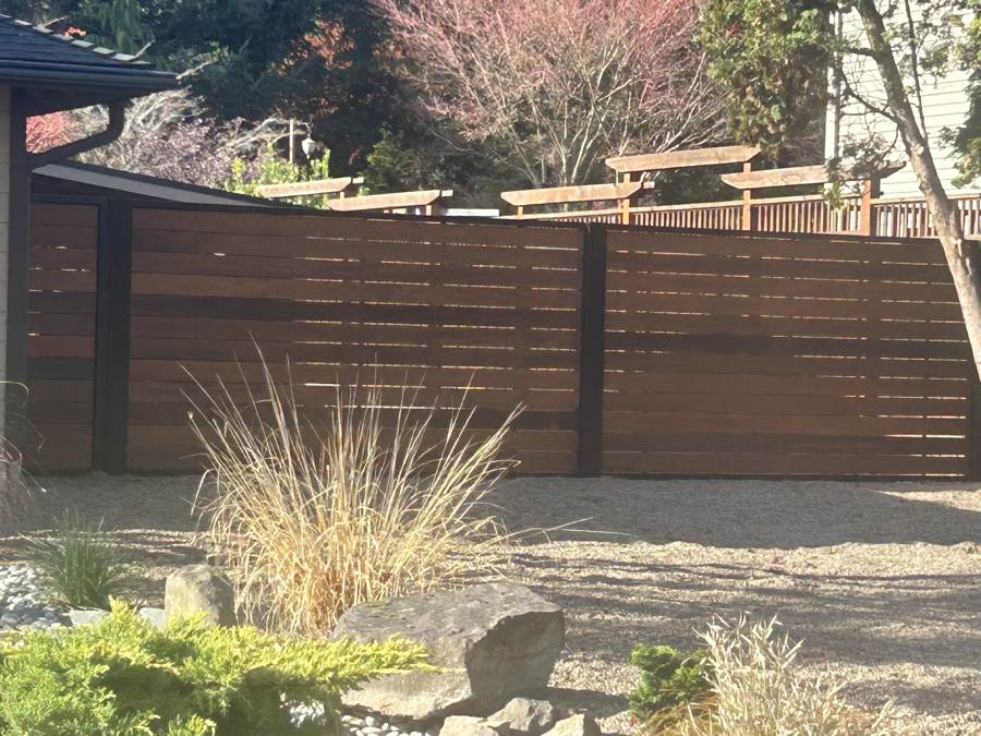 Horizontal hardwood fence with black steel posts
