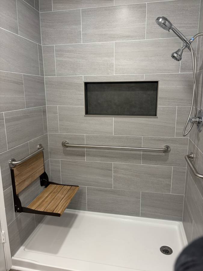 After: walk-in shower with a fold-down teak seat, grab bars and niche