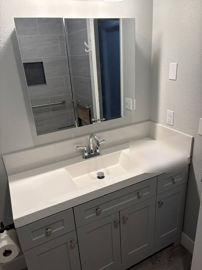 After: new vanity with a white top and chrome faucet