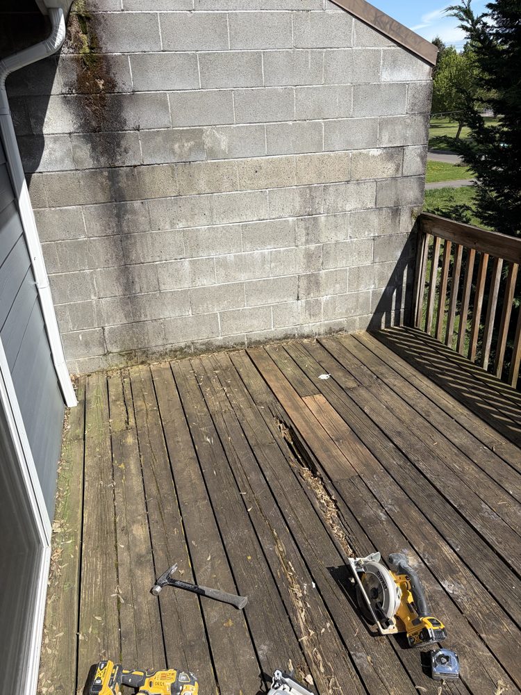 Before: rotted and split deck boards beside a block wall