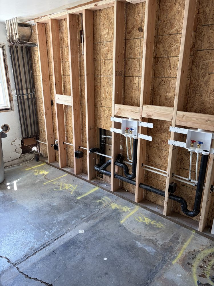 Laundry room wall framed with new plumbing for two washers