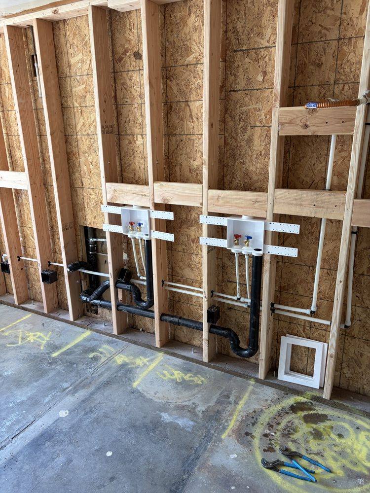 Two washer outlet boxes with new supply lines and drains in the framed wall