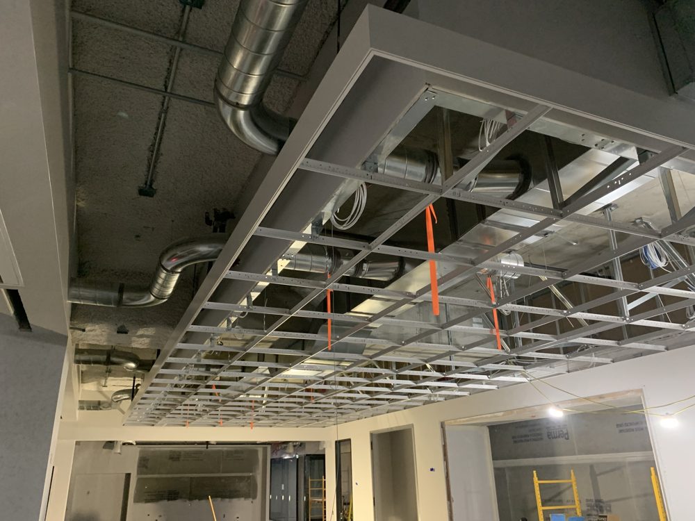 Suspended ceiling grid and drywall soffit going in around ductwork