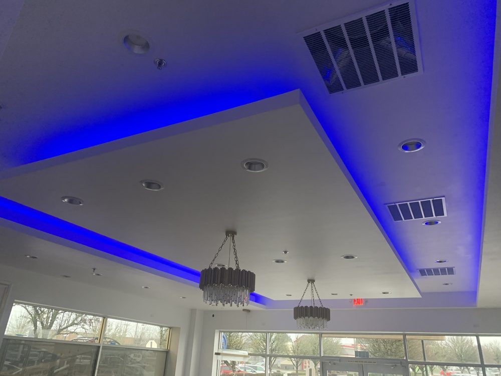 Tray ceiling with blue LED cove lighting and chandeliers