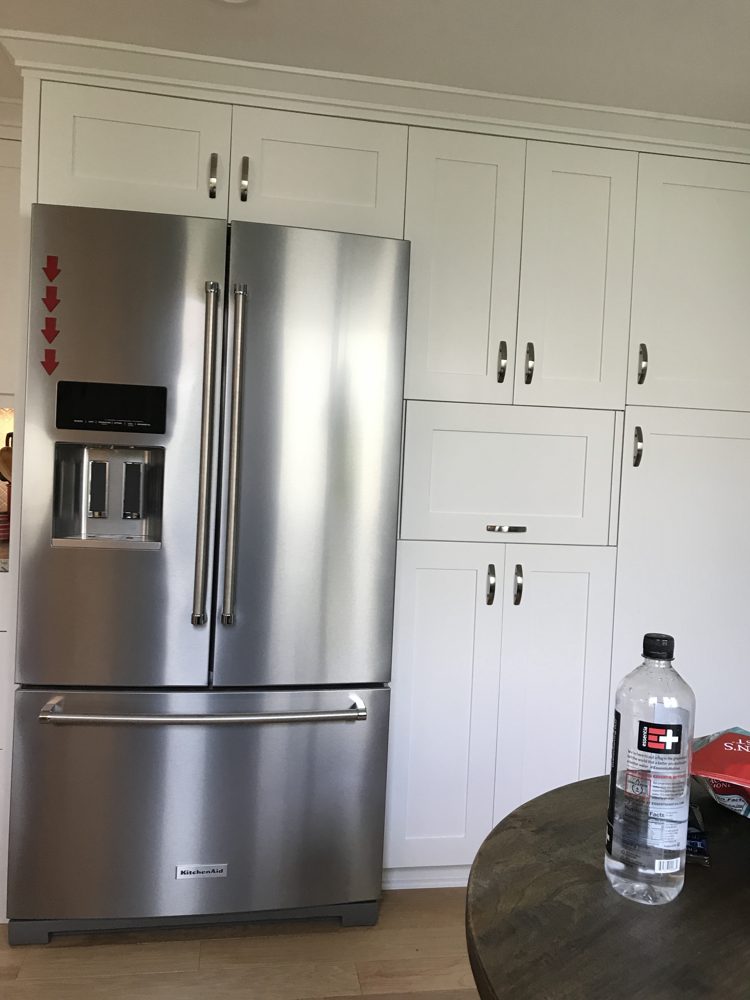 Floor-to-ceiling pantry cabinets built around the refrigerator