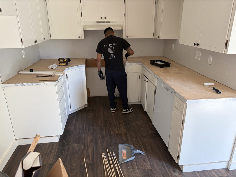 During: crew resurfacing the old countertops before laying new Formica