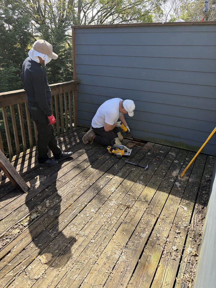 During: crew cutting out rotted deck boards along the wall